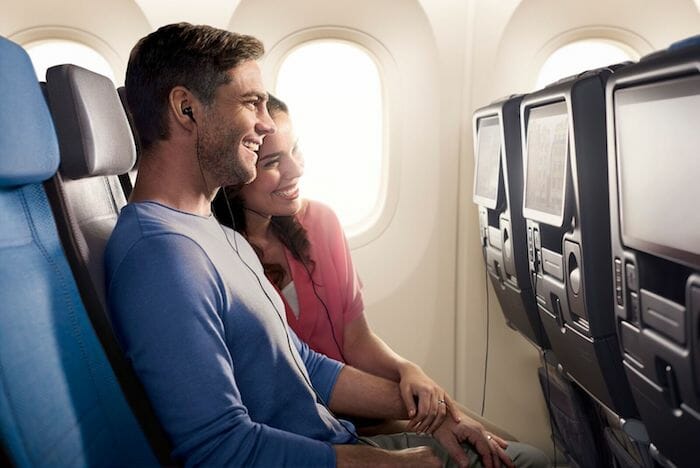 a man and woman sitting on an airplane