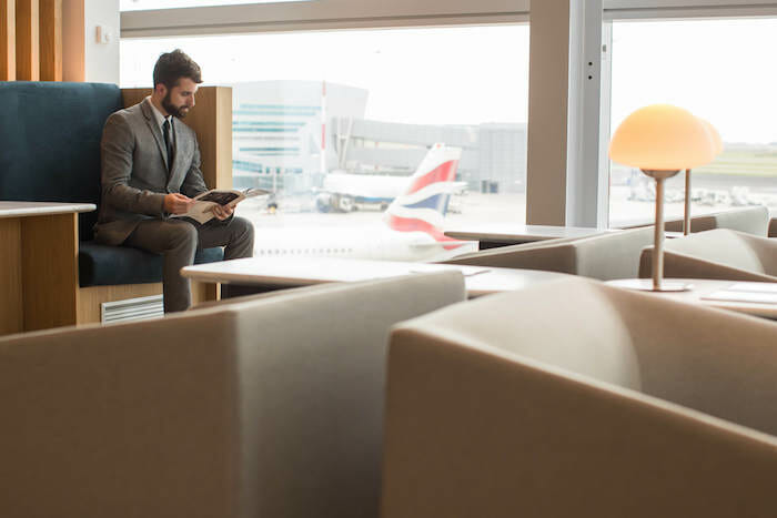 a man sitting in a chair reading a magazine