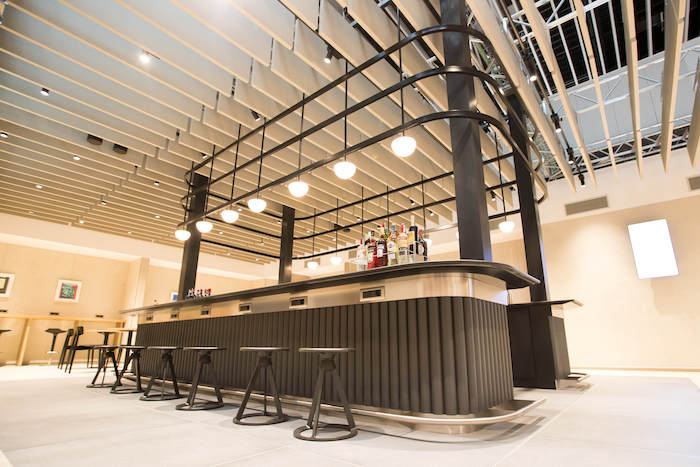 a bar with stools and bottles on top