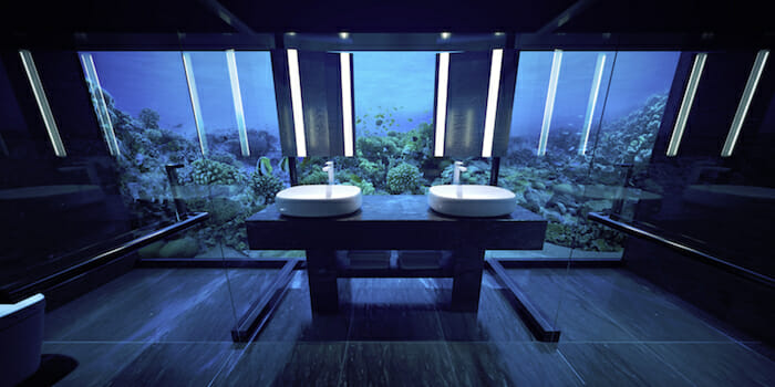 a bathroom with sinks and fish tank