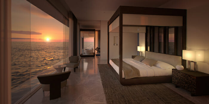 a room with a bed and a view of the ocean