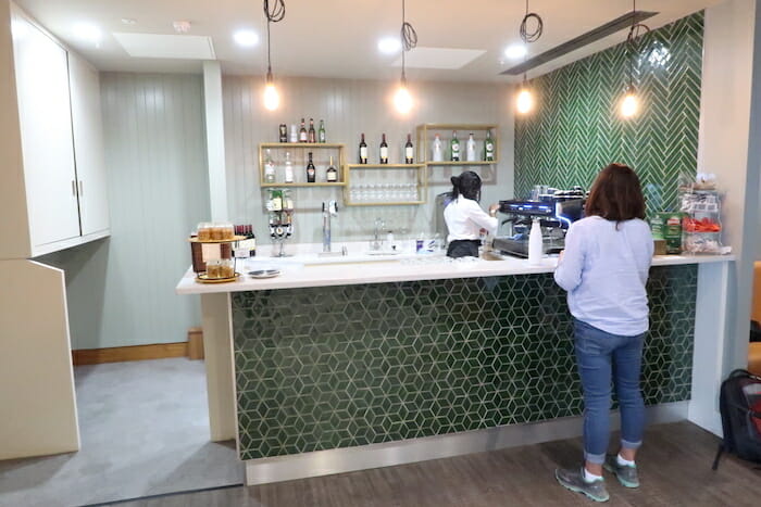 a woman standing at a counter in a coffee shop