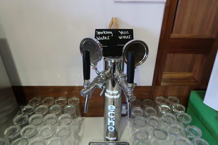 a beer dispenser with a group of glasses