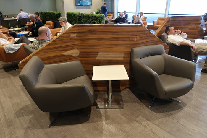 a group of people sitting in a room with chairs and a table