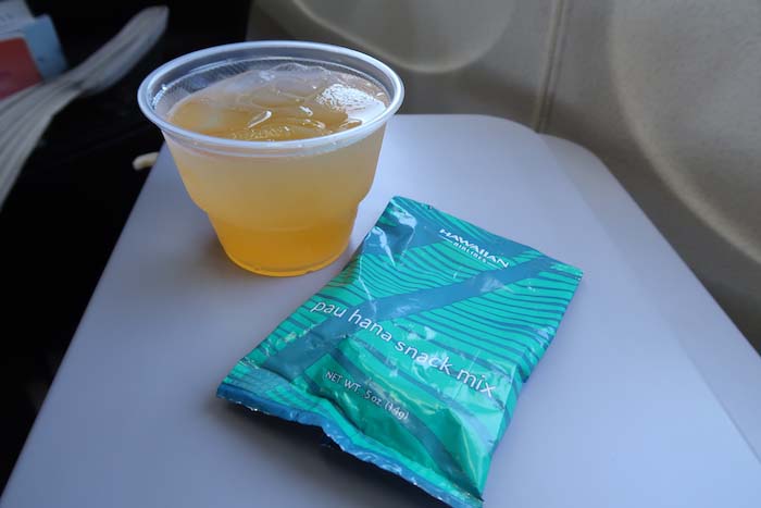 a plastic cup of liquid next to a packet of food