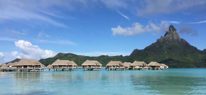 a row of huts on stilts in water