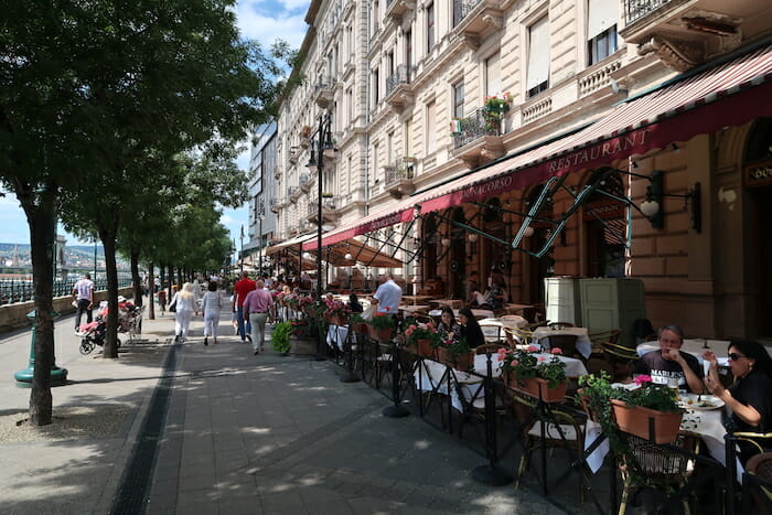 a sidewalk with tables and chairs outside of a restaurant