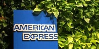 a blue sign with white text on it next to green plants