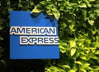 a blue sign with white text on it next to green plants