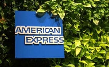 a blue sign with white text on it next to green plants