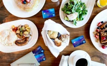a table with plates of food and credit cards