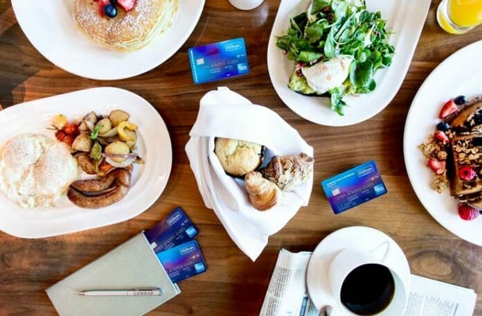 a table with plates of food and credit cards