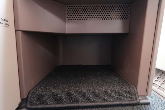 a black carpeted staircase inside a metal box