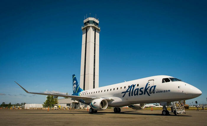 a plane parked in front of a tower
