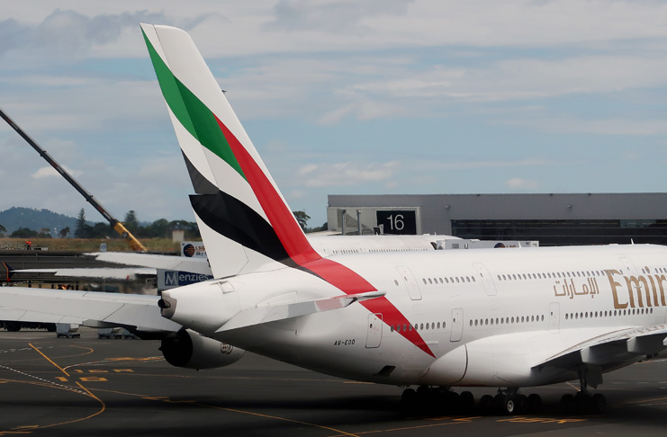 a white airplane with red and green stripes on the tail