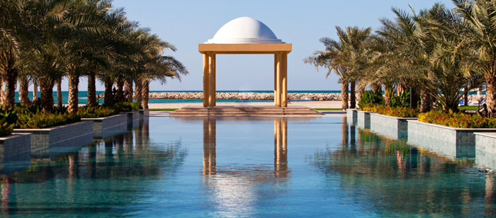 a pool with a white dome and palm trees