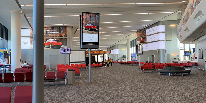 a large airport terminal with red chairs and a sign