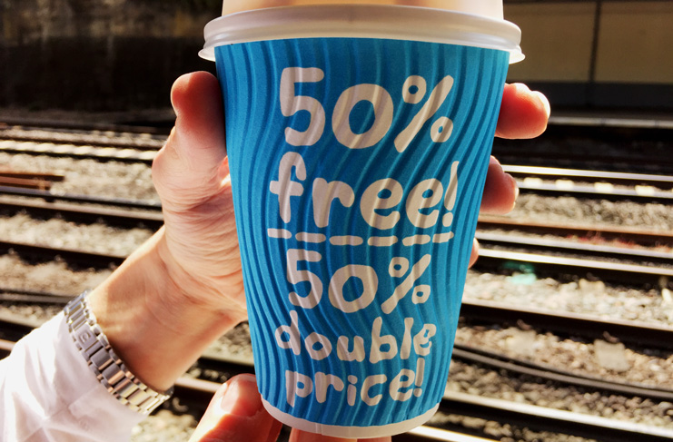 a hand holding a blue cup with white text on it