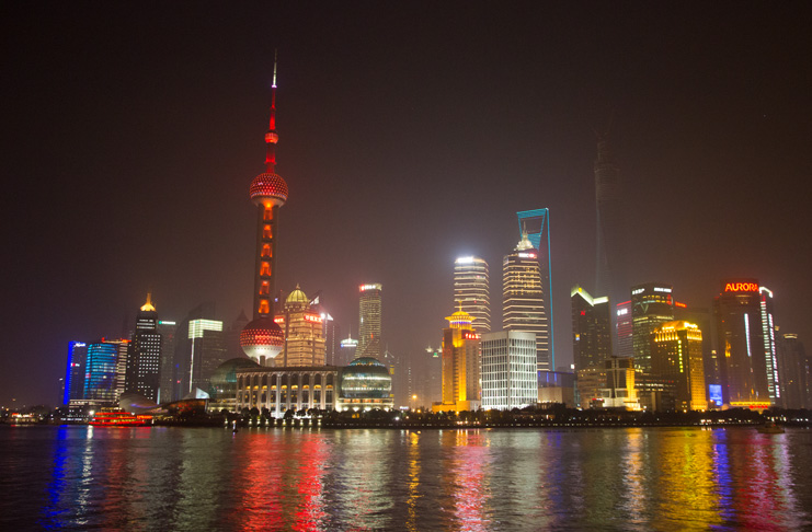 a city skyline with lights and a body of water