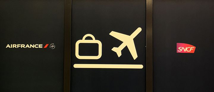 a sign with a plane and luggage on it