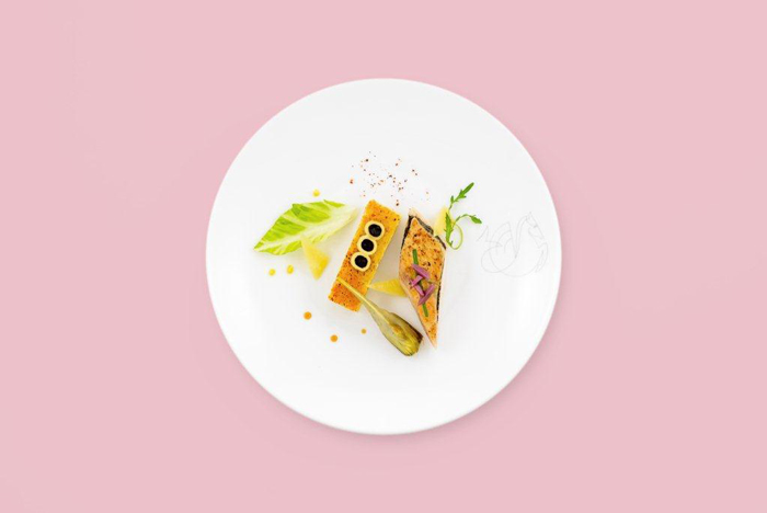 a plate of food on a pink background