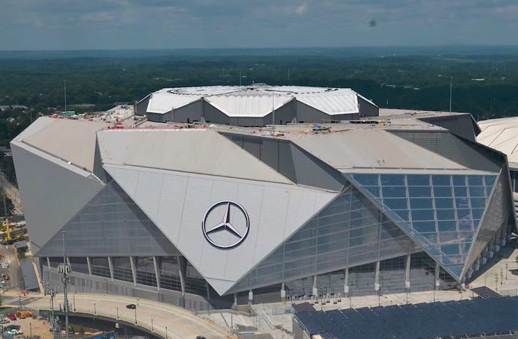 a large stadium with a mercedes logo on the roof