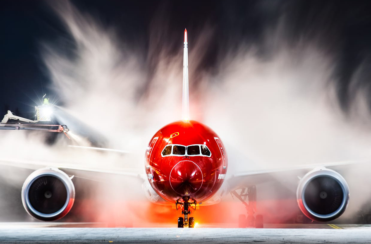 a red airplane with smoke coming out of it