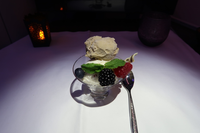 a bowl of ice cream with berries and ice cream scoop