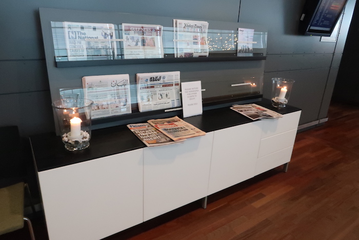 a shelf with newspapers and candles on it