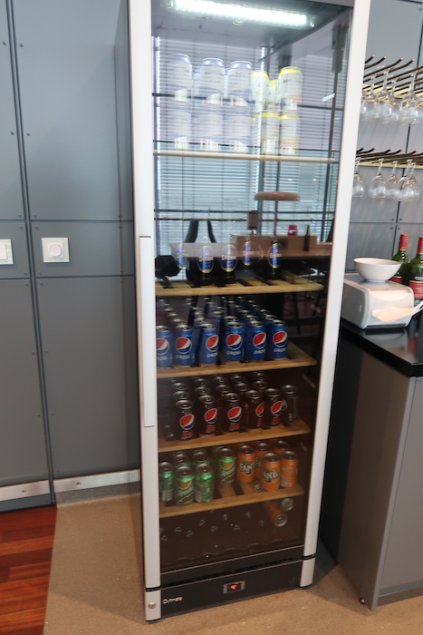 a glass case with drinks and cans on it