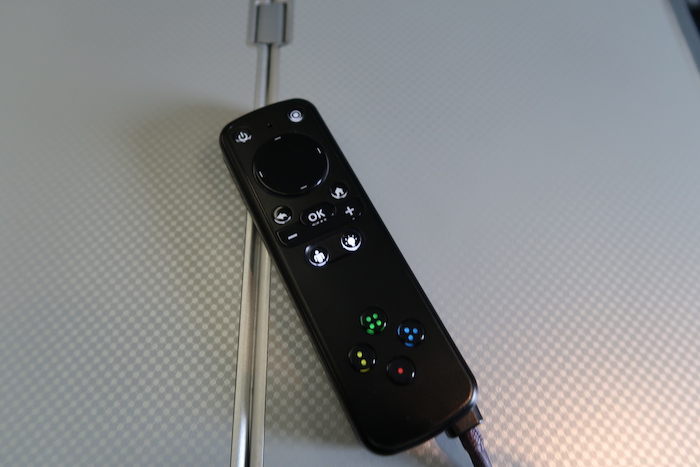 a remote control with buttons and a wire
