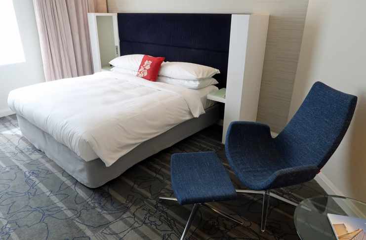 a bed with a blue chair and a blue chair