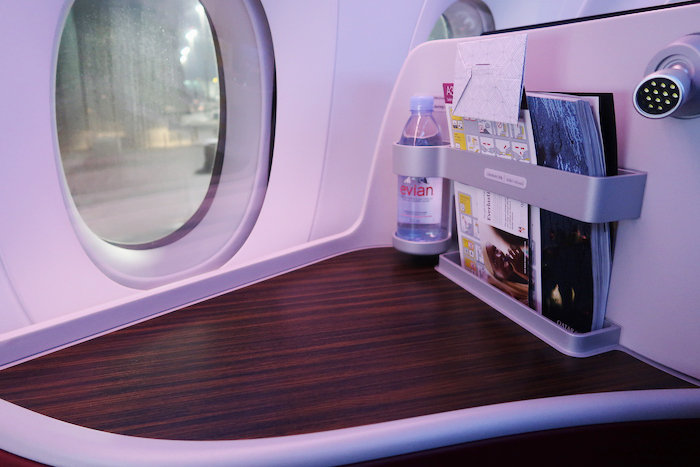 a shelf with magazines and books on a table in an airplane