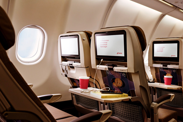 a row of monitors on a table in an airplane