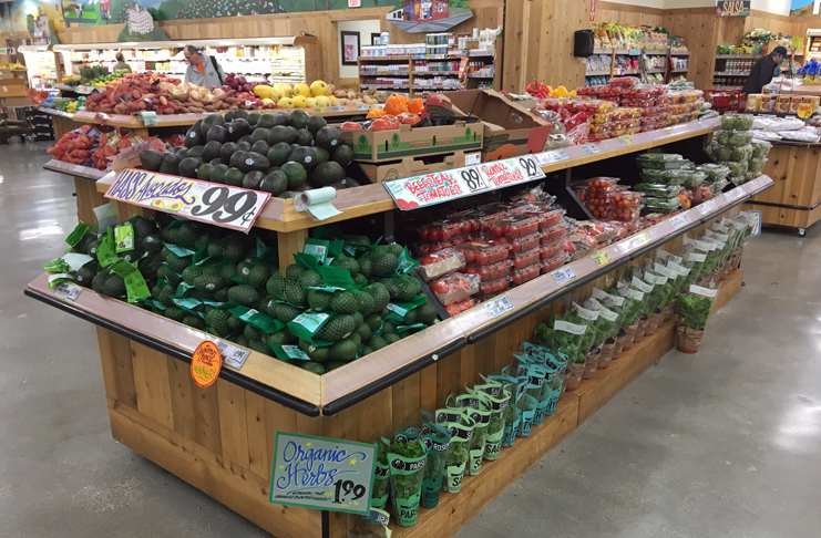 a grocery store with shelves of vegetables and fruits