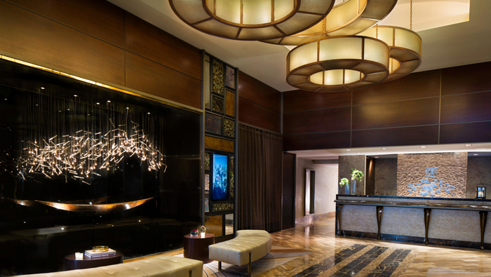 a lobby with a chandelier and a reception desk