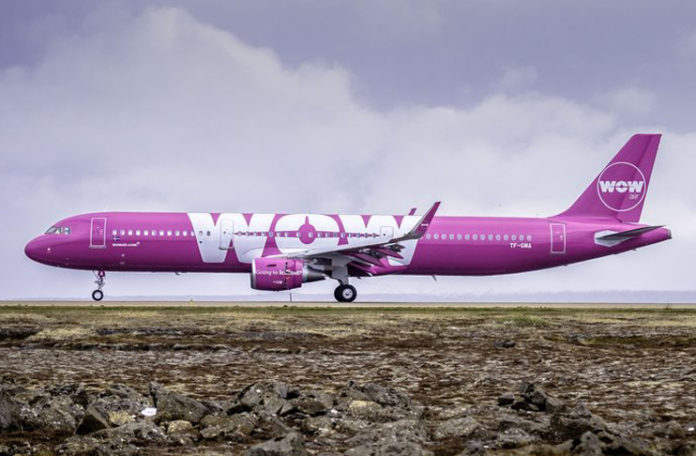 a large pink airplane on a runway