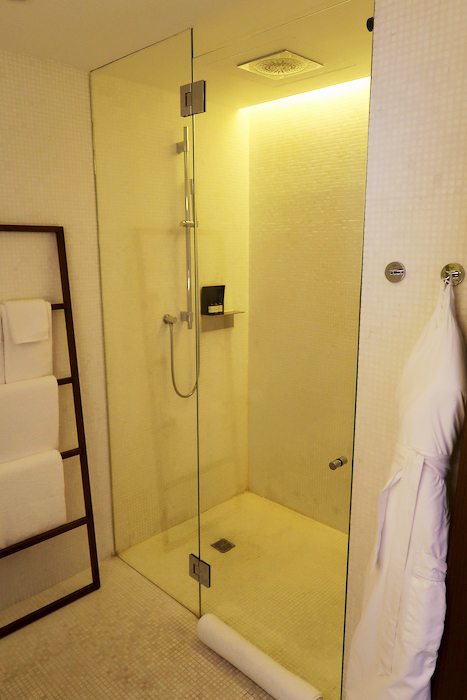 a glass shower with a white towel on a ladder