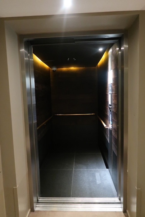 an elevator with a dark wood paneled wall
