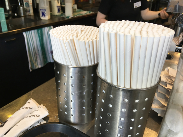 a group of straws in metal containers