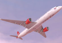 a white airplane with red engines flying in the sky