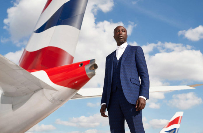 a man in a suit standing in front of a plane