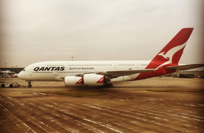 a large white and red airplane on a runway