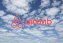 a blue sky with clouds and a logo