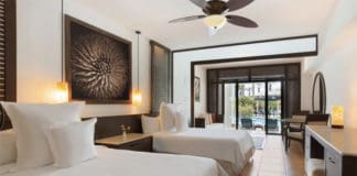 a room with two beds and a ceiling fan