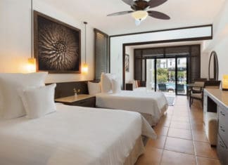 a room with two beds and a ceiling fan