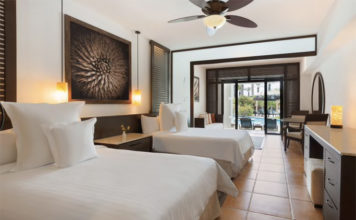 a room with two beds and a ceiling fan