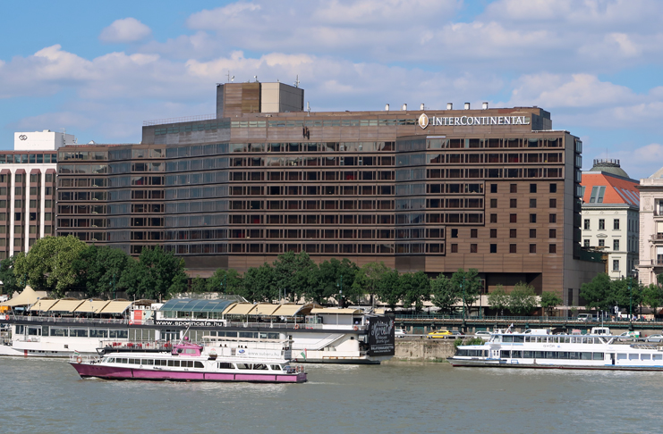 a large building with boats on the water