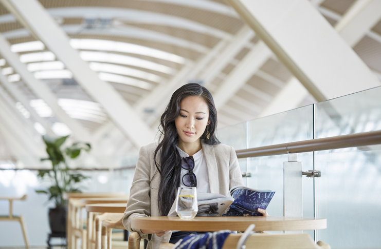 a woman reading a book at a table