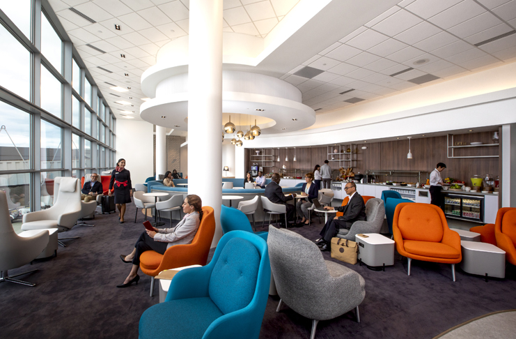 people sitting in a room with chairs and tables